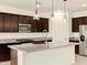New kitchen with dark cabinets, granite countertops, stainless appliances, and decorative pendant lights at 4958 W Hunter Trl, San Tan Valley, AZ 85144