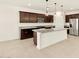 Gourmet kitchen with dark wood cabinets, stainless appliances, granite countertops, and large island at 4958 W Hunter Trl, San Tan Valley, AZ 85144