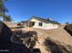 This spacious backyard features a desert landscape, a covered patio, and a block fence at 1446 S Revere --, Mesa, AZ 85210
