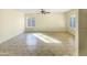 Spacious room with tile floors, large windows and a ceiling fan, offering ample natural light and a minimalist aesthetic at 1446 S Revere --, Mesa, AZ 85210