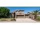 House exterior showcasing stone accents, a three-car garage, and mature trees at 1622 E Nighthawk Way, Phoenix, AZ 85048
