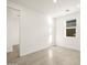 Bright spare bedroom with tile flooring and access to a hallway at 22550 W Tonopah Dr, Surprise, AZ 85387