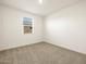 Bright bedroom with neutral walls, carpet flooring, and a window with blinds at 36914 W La Paz St, Maricopa, AZ 85138