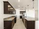 Spacious kitchen boasts granite countertops, dark cabinetry, and an island with seating at 36914 W La Paz St, Maricopa, AZ 85138