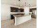 Modern kitchen with dark cabinetry, granite countertops and island at 36914 W La Paz St, Maricopa, AZ 85138