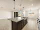 Open concept kitchen with island, pendant lighting, and granite countertops at 36914 W La Paz St, Maricopa, AZ 85138