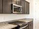 Modern kitchen features granite countertops, dark wood cabinets, and stainless steel appliances at 36914 W La Paz St, Maricopa, AZ 85138