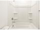 Bright bathroom showcasing a tub and shower combo with tiled walls and convenient shelving at 8612 W Warner St, Tolleson, AZ 85353