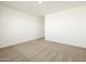 Bright, empty bedroom features neutral carpet, white walls and base trim at 8612 W Warner St, Tolleson, AZ 85353