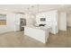 Modern kitchen boasts white cabinets, stainless steel appliances, and a center island with sink at 8612 W Warner St, Tolleson, AZ 85353