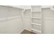 Spacious walk-in closet with shelving and hanging rods for optimal storage in neutral color palette at 8612 W Warner St, Tolleson, AZ 85353