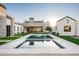 Beautiful backyard featuring a sparkling pool, lush lawn, and a stylish outdoor kitchen at 9810 N 57Th St, Paradise Valley, AZ 85253