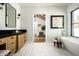Bathroom with stylish vanity, freestanding tub, and views into bedroom at 9810 N 57Th St, Paradise Valley, AZ 85253