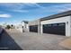 A three car garage and driveway offer ample parking with an additional building in the background at 9810 N 57Th St, Paradise Valley, AZ 85253