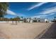 Expansive gravel backyard with a charming stone house, basketball court, and refreshing pool under a bright sky at 9810 N 57Th St, Paradise Valley, AZ 85253