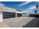 Stylish stone garage with black doors and a paved driveway leading to the property at 9810 N 57Th St, Paradise Valley, AZ 85253