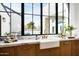 Bright kitchen features marble countertops, farmhouse sink, and a large window overlooking the backyard pool at 9810 N 57Th St, Paradise Valley, AZ 85253