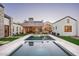 An elevated rear view of a backyard pool and stone patio surrounded by lush artificial lawn at 9810 N 57Th St, Paradise Valley, AZ 85253