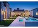 A backyard pool and spa features a stone house exterior, pavers, and artifical lawn at 9810 N 57Th St, Paradise Valley, AZ 85253