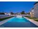 A wide backyard pool is surrounded by artificial lawn at night at 9810 N 57Th St, Paradise Valley, AZ 85253