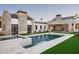 A backyard pool and spa is framed by a stone home exterior, lush lawn and landscaping at 9810 N 57Th St, Paradise Valley, AZ 85253