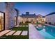 A backyard pool and spa, with a lush lawn and stone paver walkway at dusk at 9810 N 57Th St, Paradise Valley, AZ 85253