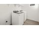 Convenient laundry room featuring a white, modern washer and dryer set with overhead shelving for storage at 20293 N 225Th Dr, Surprise, AZ 85387