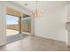 Dining area with modern chandelier, large sliding glass door to patio, and neutral tile flooring at 20357 N 225Th Dr, Surprise, AZ 85387