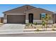 Inviting single-story home featuring a two-car garage, desert landscaping, and a classic brown stucco facade at 20357 N 225Th Dr, Surprise, AZ 85387