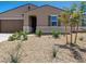 Landscaped front yard showcasing desert plants and trees complementing the house's architecture at 20357 N 225Th Dr, Surprise, AZ 85387