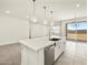 Open-concept kitchen with an island, pendant lights, stainless steel appliances, and an adjacent living area at 20357 N 225Th Dr, Surprise, AZ 85387