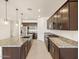 Modern kitchen with dark wood cabinets, granite counters, and an island at 22526 W Tonopah Dr, Surprise, AZ 85387