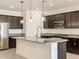 Modern kitchen with dark cabinets, granite counters, and stainless steel appliances at 22526 W Tonopah Dr, Surprise, AZ 85387