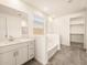 Modern bathroom with white vanity, bathtub, and shower at 36954 W La Paz St, Maricopa, AZ 85138