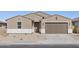 Newly constructed tan house with a brown garage door and desert landscaping at 36954 W La Paz St, Maricopa, AZ 85138