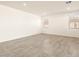 Spacious living room with gray tile floors and large windows at 36954 W La Paz St, Maricopa, AZ 85138