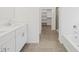 Bathroom featuring double sinks, a large bathtub, a glass door shower and a walk in closet at 20331 N 225Th Dr, Surprise, AZ 85387