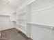 Walk-in closet featuring adjustable shelving and clean, tan carpet at 20331 N 225Th Dr, Surprise, AZ 85387