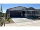 Charming single-story home featuring a stone accent facade and a two-car garage at 20331 N 225Th Dr, Surprise, AZ 85387