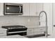 Close-up of kitchen features stainless steel appliances, modern fixtures, and stylish backsplash at 20331 N 225Th Dr, Surprise, AZ 85387