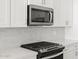Close-up of kitchen features stainless steel appliances, modern fixtures, and stylish backsplash at 20331 N 225Th Dr, Surprise, AZ 85387
