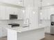 Bright modern kitchen boasts white cabinets, quartz countertops, stainless steel appliances, and a central island at 20331 N 225Th Dr, Surprise, AZ 85387