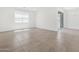 Bright, open-concept living room featuring neutral tile flooring and sliding glass door access to the exterior at 20331 N 225Th Dr, Surprise, AZ 85387