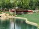 Scenic view of the Ranch House community sign surrounded by lush landscaping and a serene pond at 4196 E Bonanza Rd, Gilbert, AZ 85297