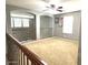 View of the living room upstairs, showcasing carpeted floors and an iron railing at 4196 E Bonanza Rd, Gilbert, AZ 85297
