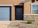 A close-up of the front entry featuring a blue front door and decorative stone accents at 4256 W Jeanette Ln, San Tan Valley, AZ 85144