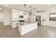 Modern kitchen features white cabinets, stainless steel appliances, and a granite island with pendant lighting at 4256 W Jeanette Ln, San Tan Valley, AZ 85144