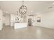 Open-concept living room with tile floors, modern lighting, and a kitchen featuring white cabinets at 4256 W Jeanette Ln, San Tan Valley, AZ 85144