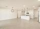 Open floor plan with tile floor, a view of the kitchen with white cabinets, stainless appliances, and a modern light fixture at 4256 W Jeanette Ln, San Tan Valley, AZ 85144