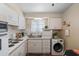 Functional kitchen with white cabinets, modern appliances, wood-look floors, and a double sink at 11038 W Windsor Dr, Sun City, AZ 85351